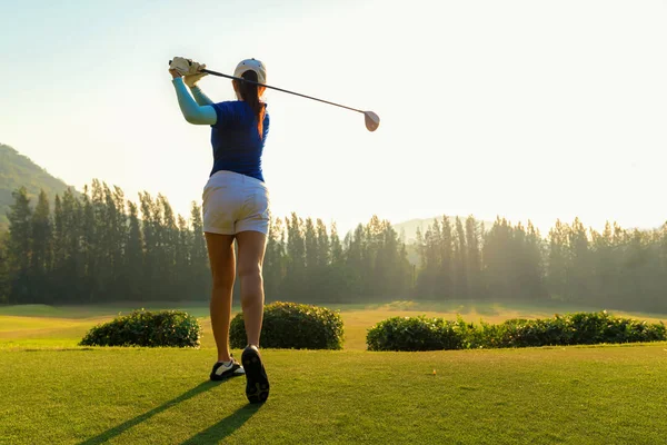 Sağlıklı spor. Golf salıncak tee yapıyor Asya sportif kadın golfçü oyuncu kapalı yeşil akşam zamanında o muhtemelen egzersiz. Sağlıklı yaşam konsepti.