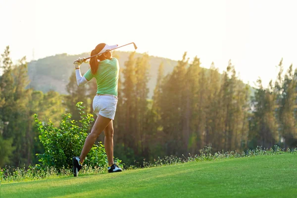 Sağlıklı spor. Golf salıncak tee yapıyor Asya sportif kadın golfçü oyuncu kapalı yeşil akşam zamanında o muhtemelen egzersiz. Sağlıklı yaşam konsepti.