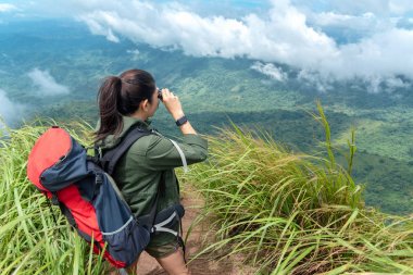 Dürbün ve dağ üzerinde duran bak uzun yürüyüşe çıkan kimse Asya kadın. Kadın macera sırt çantası ve kamp üzerinde açık doğada uzun yürüyüşler. Seyahat kavramı