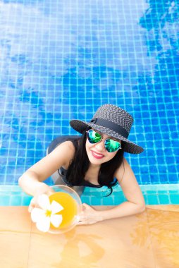 Yaz saati ve tatiller. Kadınlar yaşam tarzı rahatlatıcı ve içme suyu portakal çok mutlu lüks yüzme havuzu güneşlenme, otelde beach resort yaz günü. Yaz Concep