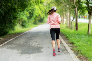 Yolda koşan sportif kadın Runner. Bir parkta egzersiz. Bir parkta açık egzersiz. Kilo kaybı ve sağlıklı konsept
