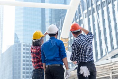 İnşaat alanında mavi baskı yapmayı planlayan mimar mühendis ekibi. İşçi güvenlik kontrolü. Şehir Arkaplanı