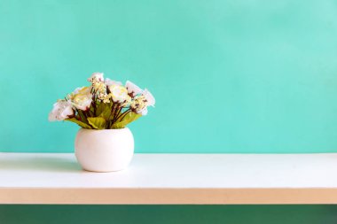 Raf beyaz ahşap çiçek ile Yeşil duvar, metin için kopya alanı. Natürmort ve Yaşam Tarzı Kavramı