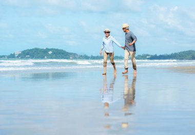 Asya Lifestyle üst düzey çift sahilde çalışan mutlu ve dinlenmek zaman. Turizm yaşlı aile seyahat eğlence ve aktivite emeklilik tatil ve yaz sonrası.