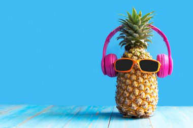 Partide yaz. Hipster Ananas Moda güneş gözlüğü ve müzik tatil parlak güzel renk, plaj vibes tropikal tarzı için Yaratıcı sanat meyve, mavi arka plan. Moda Yaz Tatil Konsepti