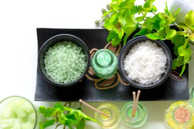 Tay Spa Tedaviler aroma terapi tuz ve doğa yeşil şeker scrub ve mum ile ahşap beyaz yeşil orkide çiçek ile kaya masajı. Tayland. Sağlıklı Konsept