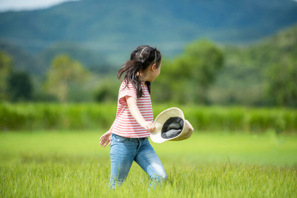 Asian girl bright running and enjoy in the field meadows outdoors, adventure and tourism for destination leisure trips for education and relax in nature park. Travel vacations and Life Concept