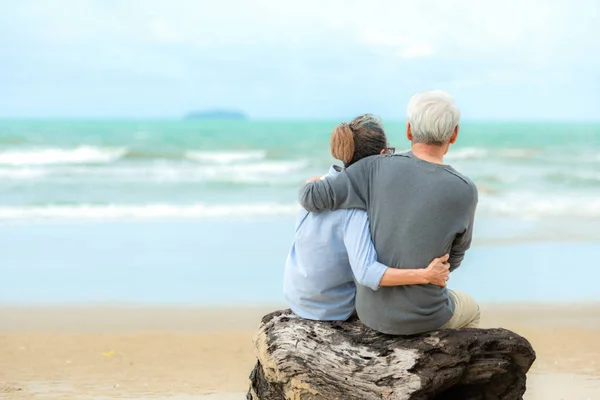 Asian Lifestyle senior couple hug and sitting on the beach happy in love romantic and relax time. Tourism elderly family travel leisure and activity after retirement  vacations and summer