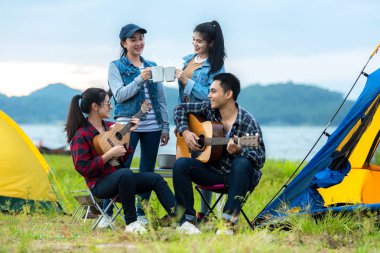 Dışarıda kamp var. Grup arkadaşlar kamp eğlence ve hedef seyahat. Aile kamp ateşi etrafında oturan ve gitar ve kavrulmuş sosis oynarken, turizm dinlenmek ve tatil nehir yakınında seyahat.