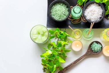 Tay Spa Tedaviler aroma terapi tuz ve doğa yeşil şeker scrub ve mum ile ahşap beyaz yeşil orkide çiçek ile kaya masajı. Tayland. Sağlıklı Konsept.