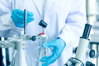 Ekip çalışması Bilim adamları çalışma verilerini analiz ve iş atölyesi için mikroskop başarısını değerlendirir. Yaşam bilimi laboratuvarında damlalık kimyasal test ile bazı araştırma yapan sağlık araştırmacıları