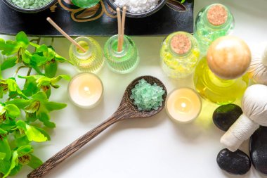 Tay Spa Tedaviler aroma terapi tuz ve doğa yeşil şeker scrub ve mum ile ahşap beyaz yeşil orkide çiçek ile kaya masajı. Tayland. Sağlıklı Konsept