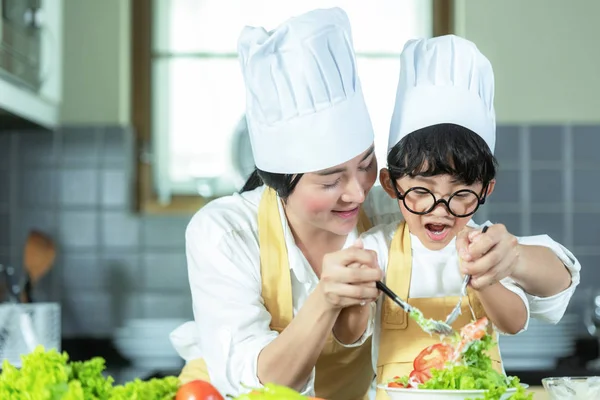 亚洲小男孩帮助妈妈做饭和切蔬菜混合健康沙拉在厨房 所以快乐和放松的倾斜和教育做饭 生活方式与家庭观念 — 图库照片