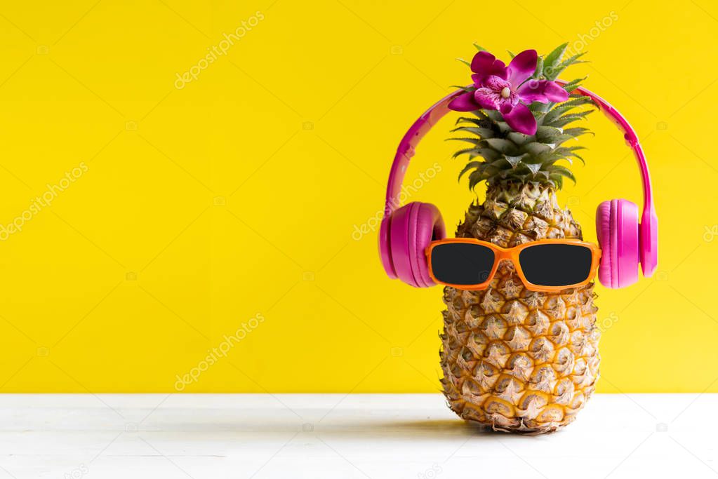 Summer in the party.  Hipster Pineapple Fashion in sunglass and music bright beautiful color in holiday, Creative art fruit for tropical style on the beach vibes, yellow background.  Fashion Summer Vacation Concep