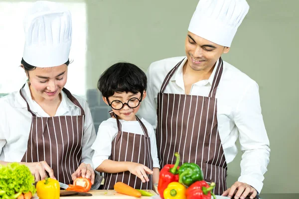 健康家庭 父亲和母亲与儿子一起烹饪沙拉新鲜蔬菜 在厨房里节食 微笑的小男孩帮助家人制作饼干 在假期里快乐和享受 家庭概念 — 图库照片