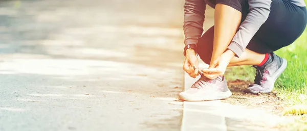 Lauffrau bindet Schnürsenkel von Laufschuhen — Stockfoto