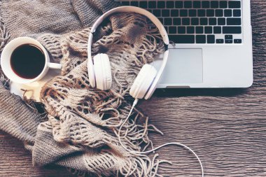 Sıcak kış arkaplanı, mevsiminde marşmelovlu bir fincan sıcak kahve, eski ahşap arka planda sıcak örülmüş süveter, klasik ton. Yaşam tarzı kavramı