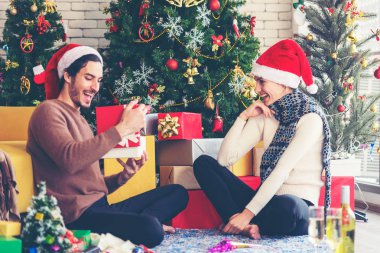 Mutlu noeller. Kız arkadaşı Noel hediyesiyle erkek arkadaşına sürpriz yapıyor. Genç bir çift yeni yıl ve Noel 'i kutluyor, parti yapıyor ve şampanya içiyor.. 