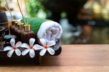 Tayland spa kompozisyonu aroma terapisi mumlar ve ahşap masa üzerinde Plumeria çiçekleri. Sağlıklı ve rahat.