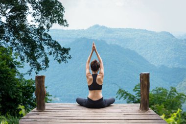 Sağlıklı kadın yaşam tarzı dengeli meditasyon yapıyor ve Zen enerjisi yogası yapıyor. Sabahları köprüde dağ doğası. Sağlıklı Yaşam Konsepti.