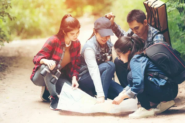 团体亚洲朋友带着背包探险游人坐着 查看地图 寻找方向 并在丛林森林中散步放松 到目的地度假休闲教育自然 旅行和生活方式概念 — 图库照片