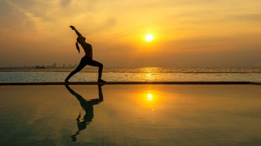 Yaşam tarzı kadın yoga egzersizi ve sağlıklı yaşam için poz vermek. Genç kız ya da insanlar vücut dengesini dengelemek için zen ve meditasyon için siluet gün batımı doğa arka planı. Sağlıklı Konsept
