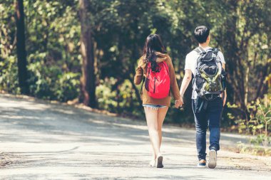 Turist Asyalı çift doğa dostu yeşil ormanı geziyor ve keşfediyor. Sırt çantalı macera haritası. Kampı bulmak için yol haritası.
