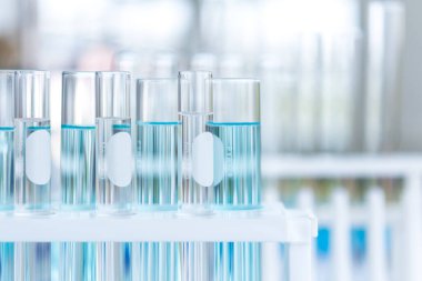 Pipette 'in laboratuvarda metal mercekli küçük organizmaların anatomisi, biyoloji ve tıbbi konsept araştırmaları için test tüpüne örnek bırakmasını kapat..