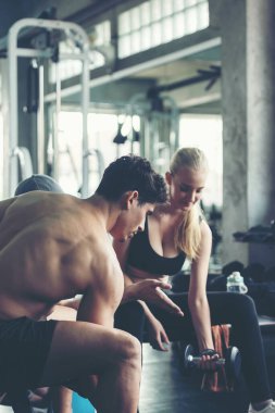 Spor salonunda erkek ve kadınla beden sağlığı ve zayıflığı eğitimi egzersizi. Beden eğitimi eğitmeni müşterileriyle spor yapıyor. Diyet ve Sağlıklı Spor Konsepti