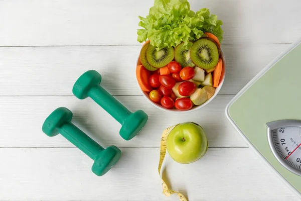 Diet Health food and lifestyle health concept. Sport exercise equipment workout with green apple and measuring tap, fresh salad for fitness style. Healthy Lifestyle Concept