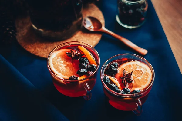 İki bardak sıcak bir içecek ile karanlık bir masa örtüsü şarap mulled
