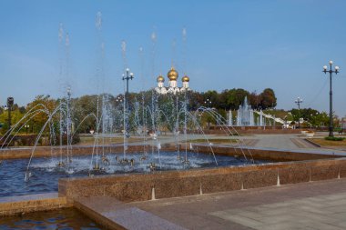 Mavi bir gökyüzü ve park çeşmeler ön planda karşı beyaz bir tapınağın altın kubbesi
