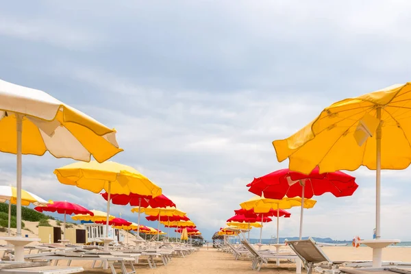 Boş bir plajda sarı ve kırmızı şemsiye pitoresk satırlar, Anapa, Rusya — Stok fotoğraf