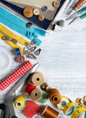 Beyaz boyalı ahşap arka planda dikiş aletleri ve aksesuarlar