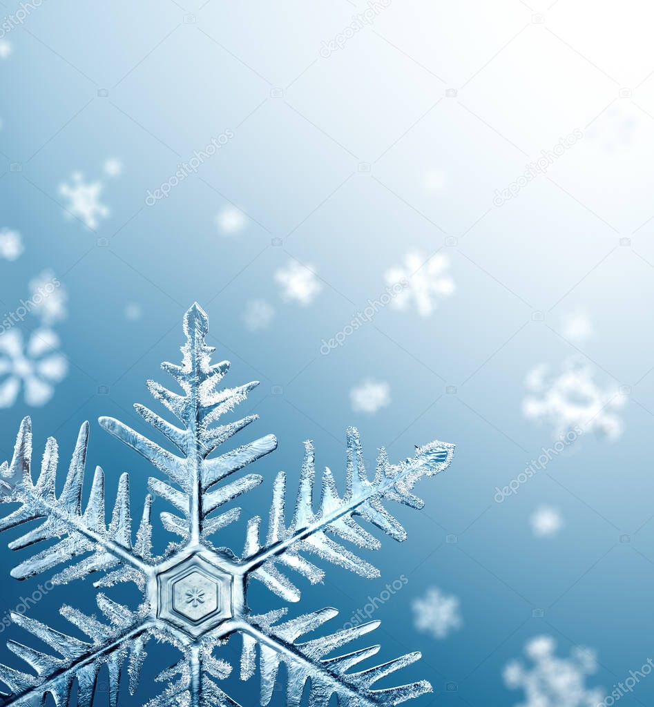 Macro snowflake and fallen defocused snowflakes on blue background
