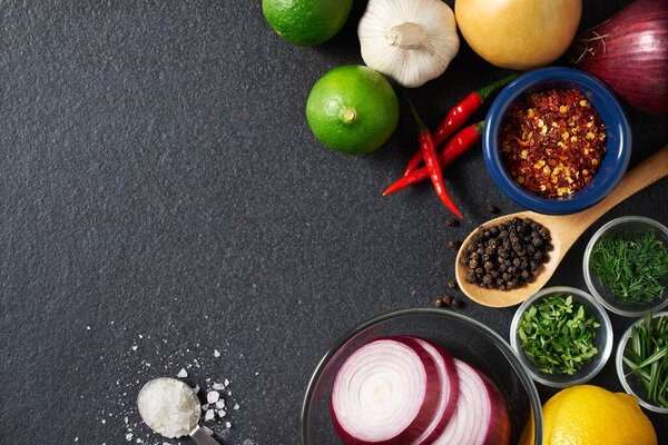 Spices and food ingredients on slate background with copy space