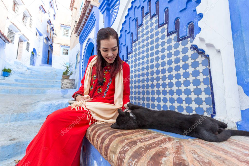 woman posing with cat on bench in Chefchaouen, Morocco