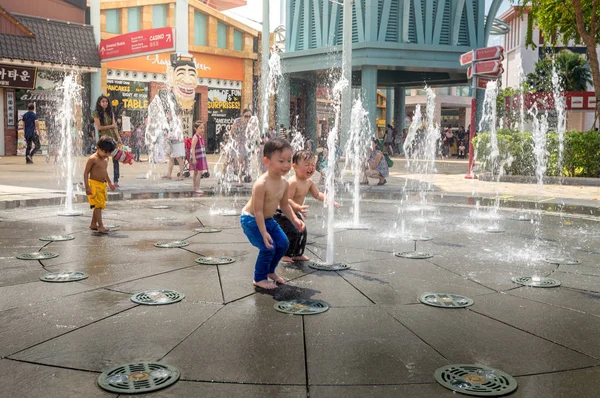 昼間は噴水で遊ぶアジア系の子供たち ストック写真