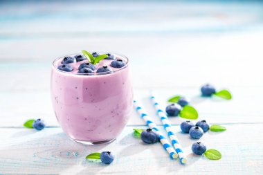 Ev yapımı güler yüzlü ve ahşap arka plan üzerinde taze yaban mersini bir kase