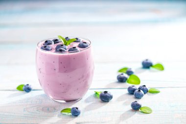 Rustik turkuaz arka plan üzerinde taze yaban mersini ile ev yapımı güler yüzlü.