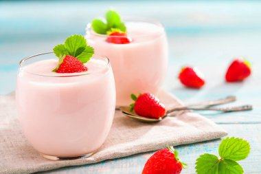 ev yapımı yoğurt turkuaz ahşap arka plan üzerinde taze çilek ile iki porsiyon