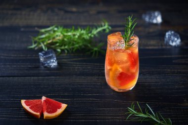 Cin kokteyli biberiye ve greyfurt siyah bir arka plan, seçici odak.
