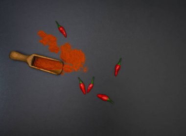 Kırmızı biber biber bakla ve siyah arka plan, üstten görünüm üzerinde ahşap kürek tozu