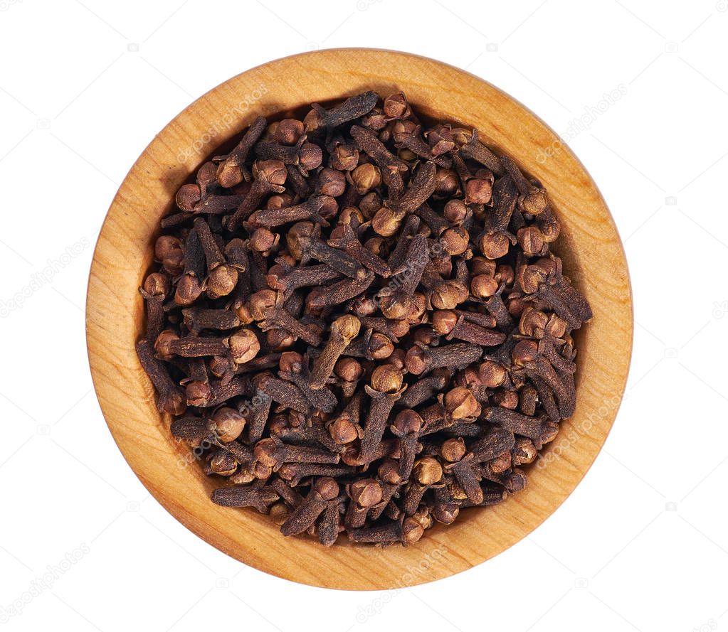 Cloves in wooden bowl isolated on white. Whole cloves.Top view