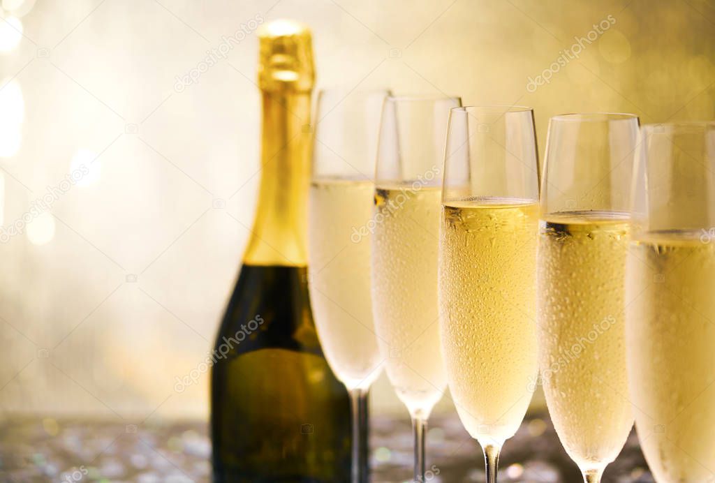 Many glasses of champagne in a line. Gold background