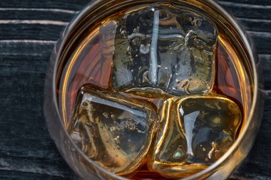 Viski ile buz üstünde siyah bir ahşap masa ahşap bir masaya. Yakın çekim.