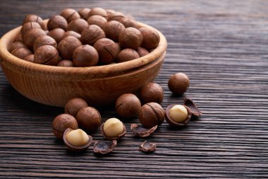 Kahverengi ahşap masa üzerinde ahşap kase fıstık. Seçici odak