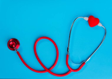 Tıbbi ekipman: mavi arka plan üzerinde kırmızı stetoskop. Dünya Sağlık günü. Tıp kavramı.