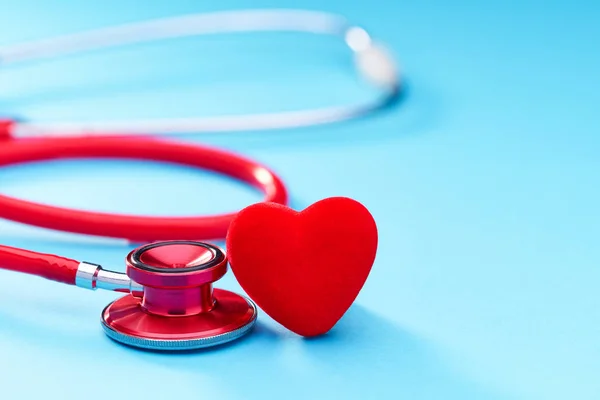 Tıbbi ekipman: mavi arka plan üzerinde kırmızı stetoskop.
