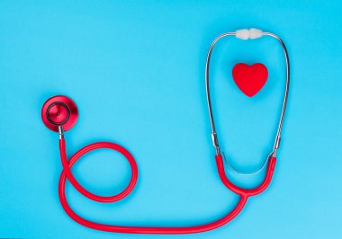 Tıbbi ekipman: kırmızı stetoskop veya mavi zemin üzerine phonendoscope. Dünya Sağlık günü. Tıp kavramı.
